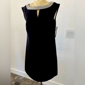Black party dress embellished with rows of sophisticated and elegant pearls.